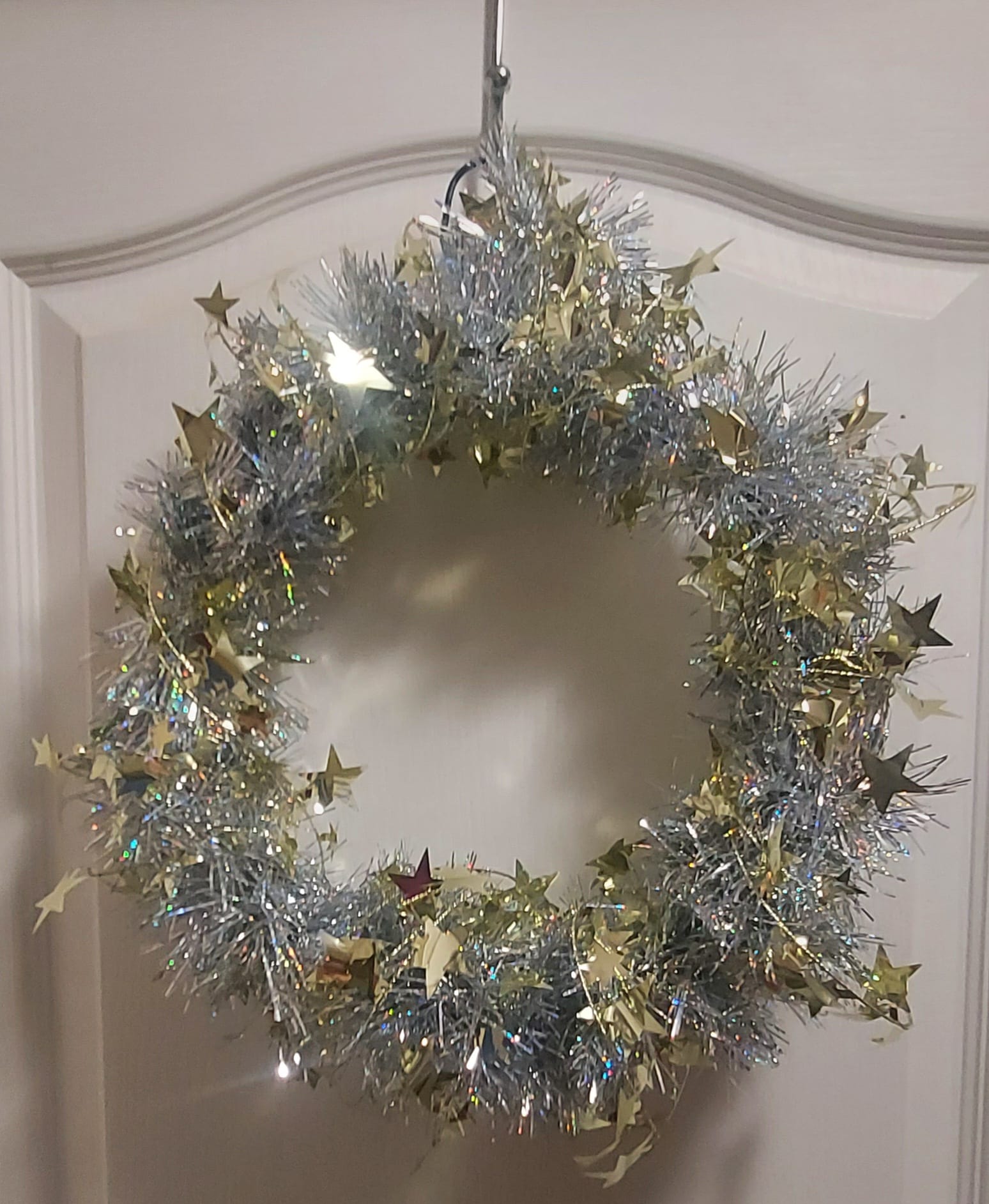 A wreath made of shiny things on strings found at the dollar store